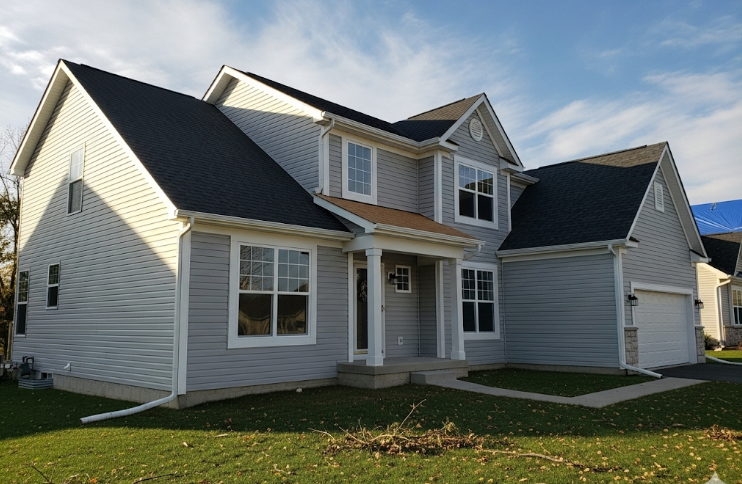 residential home with gutters, siding, and roofing newly restored after storm damage.