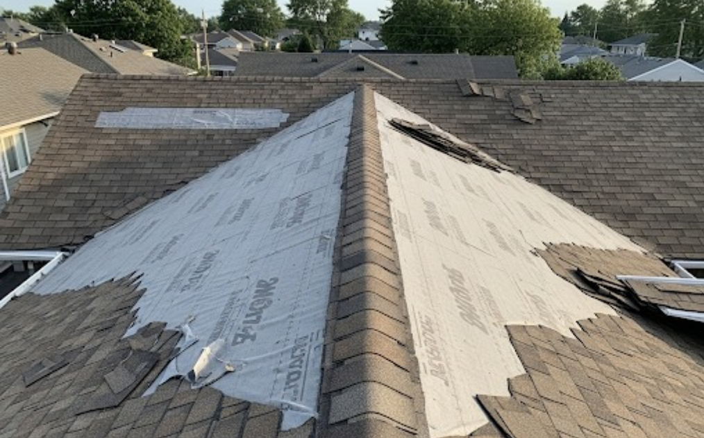 Rooftop view showing missing shingles with visible underlayment beneath