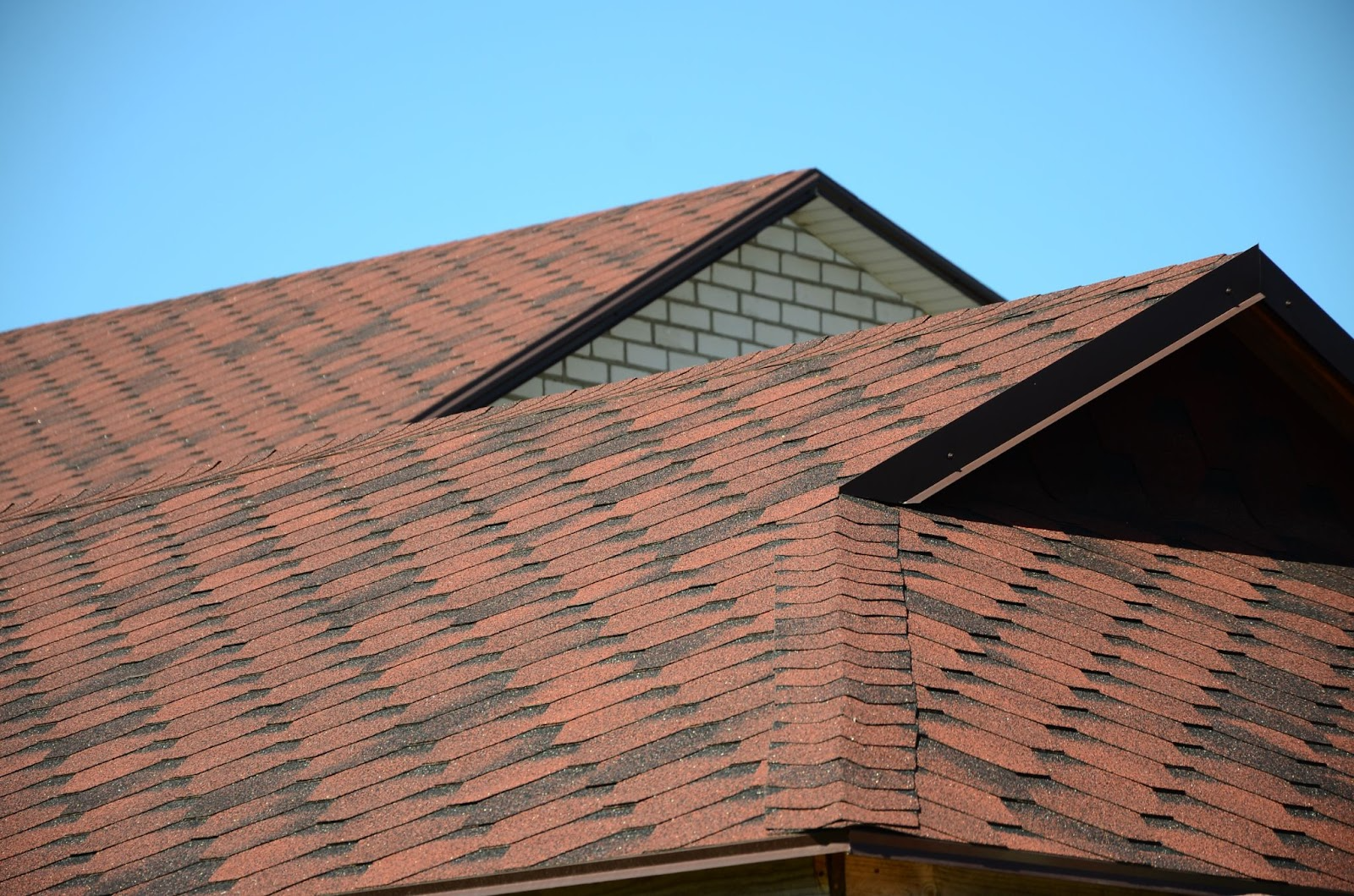 roof with brown bituminous shingles, symbolizing durability and trust in roofing and solar projects
