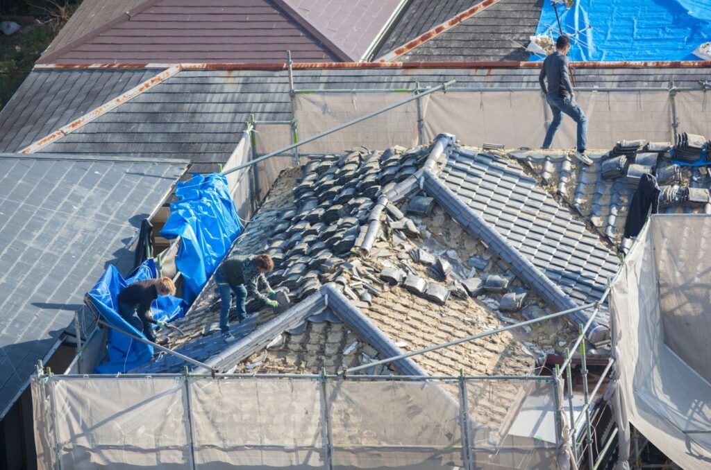 people working to tile a roof