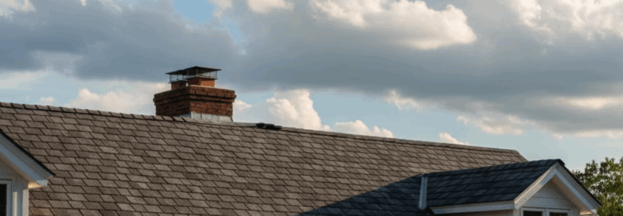 roof with asphalt shingles under cloudy sky, representing the importance of home roof repairs in DFW