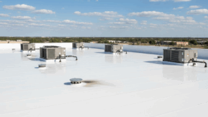 A large commercial flat roof with clean white TPO membrane, drains, and HVAC units, representing the work of flat roofing contractors