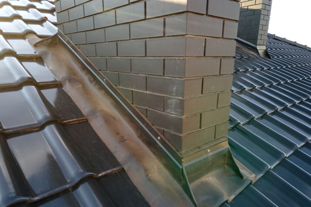 chimney flashing on a tile roof, showing workmanship by a licensed roofing contractor for homeowners searching “handyman roof repair near me.”