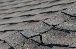 cracked asphalt shingle, underscoring understanding how to repair roof cracks