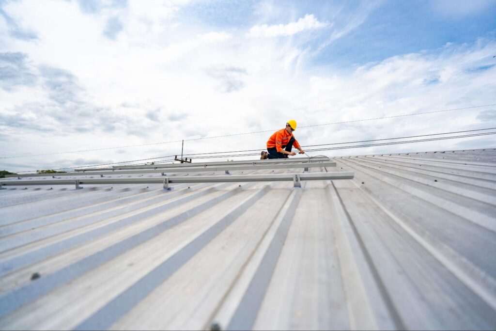 worker on top of metal roof